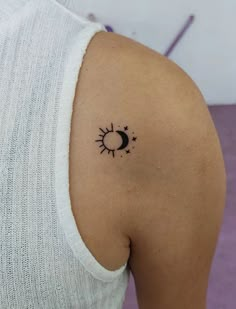 a woman with a small sun and moon tattoo on her shoulder