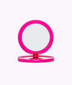 a pink compact mirror on a white background