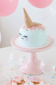 there is a cake on the table with unicorn decorations