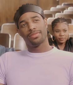 the man is wearing a head band and standing in front of two other people behind him