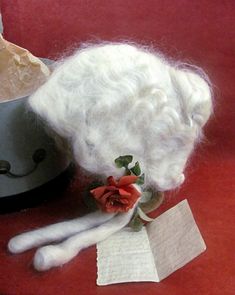 A unique find, an antique white human wig in the original box. The wig is in the colonial style, similar to Betsy Ross, the maker of the first American flag. There is a small rust colored flower attached to the wig just above the two long curls. There is a bun attached to the back of the wig, fastened by hair pins. Also included was a small piece of paper with hand writing in pencil. It appears to be the 'lines' that the wearer would recite for the performance in which she was wearing the wig as part of the costume. The previous owner's name is written on the box cover in pencil; Property of Isabel T. Peirce. "And now behold us united for our beloved land. Dearly we treasure freedom the heritage of our fathers, and hallowed by their memory the torch of Liberty shall ever burn brightly on t First American Flag, Wig Companies, Betsy Ross, Human Wigs, Hand Writing, Long Curls, Ny City, The First Americans, Clothing And Textile