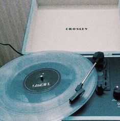 an old record player sitting on top of a table next to a box with the word crossley printed on it