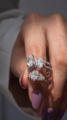 a woman's hand with two rings on top of her finger and one ring in the middle