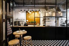 the interior of a restaurant with black and white checkered flooring on the walls