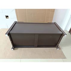 a brown cabinet sitting on top of a tiled floor