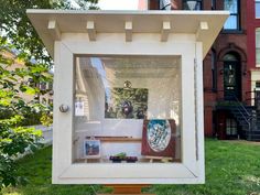 a display case in the shape of a house with pictures and other items on it