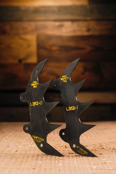 two black scissors sitting on top of a wooden table