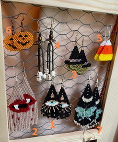 a bunch of beaded earrings hanging on a wire mesh rack in front of a door