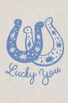 a drawing of a blue horse shoe with the words lucky you written in white ink