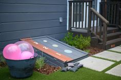 there is a pink ball and some balloons in the yard