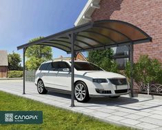 a white car is parked in front of a brick building with an awning over it