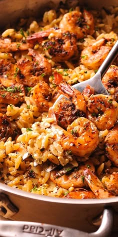 shrimp and rice in a skillet with a serving spoon