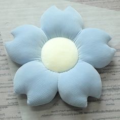 a blue flower sitting on top of a piece of paper