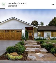 a house with steps leading up to the front door and landscaping in front of it