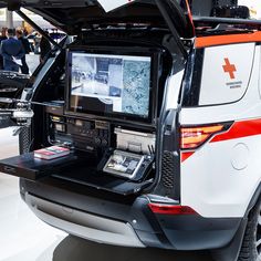 the back end of a white van with an open trunk on display at a car show