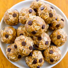 a white plate filled with chocolate chip cookie energy bites on top of a wooden table