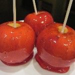 three red apples sitting on top of each other with toothpicks sticking out of them