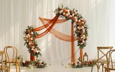 an orange and white wedding arch decorated with flowers