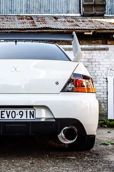 a white car parked in front of a brick building