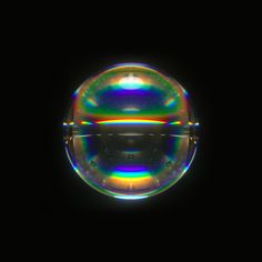 a soap bubble floating in the air on a black background