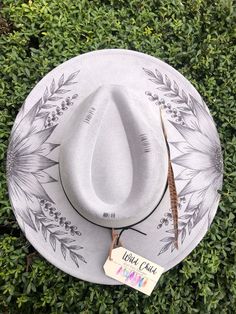 a white hat sitting on top of a lush green field next to a name tag