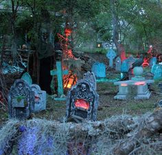 an outdoor cemetery is lit up with colorful lights and decorations on the ground, including tombstones