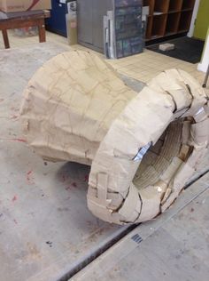 a large piece of cardboard sitting on top of a floor next to a metal object