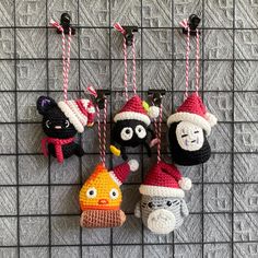 crocheted christmas ornaments hanging from hooks on a wire rack in front of a wall