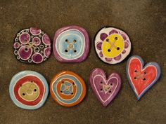 five ceramic buttons with different designs on them sitting on the ground next to each other