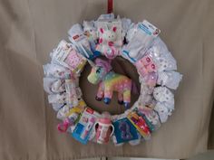 a wreath made out of baby items is hanging on the wall