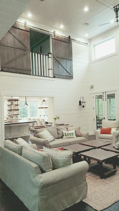 a living room filled with furniture and lots of windows in the middle of it's walls