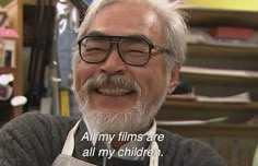 an older man with glasses and a beard smiles at the camera while wearing an apron that says, all my films are all my children