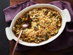 a casserole dish with broccoli and rice in it on a purple napkin