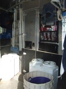 a man standing in front of a white container filled with water next to a refrigerator