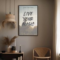 a room with a chair, table and poster on the wall that says live your magic