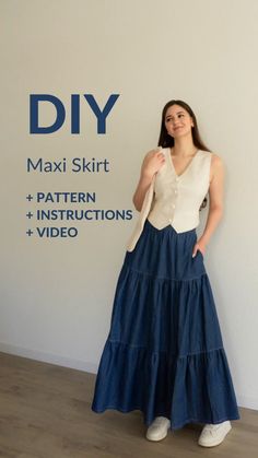 a woman standing in front of a white wall wearing a blue skirt with ruffles