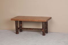 a wooden table sitting on top of a carpeted floor next to a beige wall