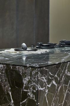 a black marble table with some silver objects on it