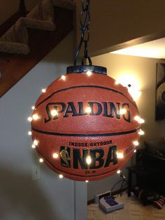 a basketball hanging from the ceiling with lights on it and an ad for spalding