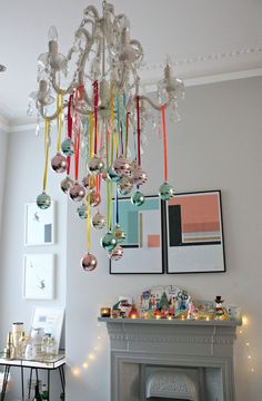 a chandelier hanging from the ceiling in a living room next to a fireplace