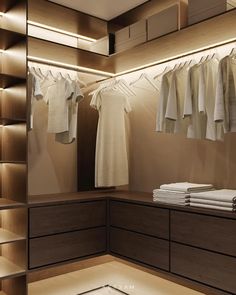 an empty closet with clothes hanging from the ceiling and folded shirts on hangers in front