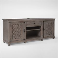 an old style entertainment center with carvings on the doors and drawers, is shown in grey