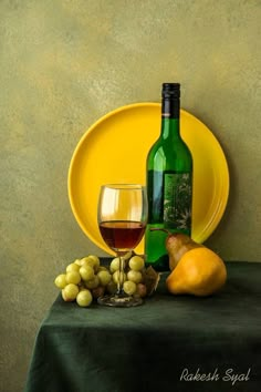 a yellow plate with grapes, pears and a bottle of wine sitting on a table