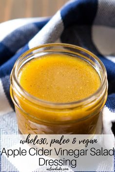 a glass jar filled with mustard sitting on top of a blue and white towel