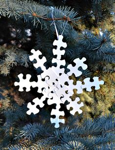 a white snowflake ornament hanging from a tree