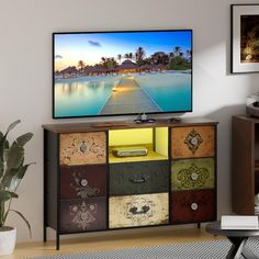 a flat screen tv sitting on top of a wooden cabinet