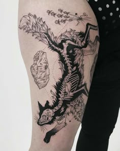 a woman's thigh with a tattoo on it and an image of a dragon