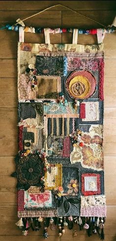 a wall hanging made out of old pieces of cloth and other things on a wooden floor