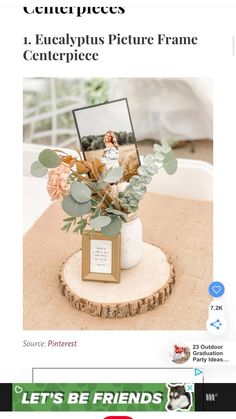 a vase filled with flowers and greenery on top of a wooden table next to a photo frame