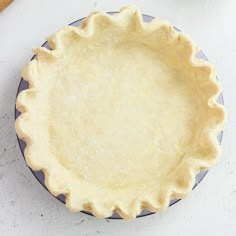 an uncooked pie crust sitting on top of a blue and white plate